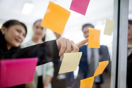 Woman pointing at sticky note 