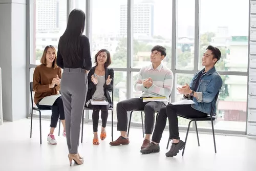 Teammates listening to female coworker 